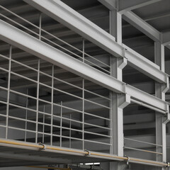 Obraz premium Close-up view of industrial scaffolding and metal framework with guard rails in a factory setting