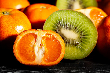 sliced tangerine kiwi mix on black background