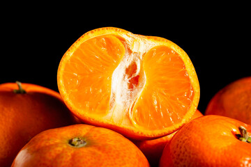 sliced tangerine heap on black background