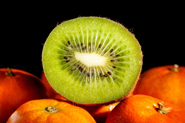sliced kiwi tangerine on black background