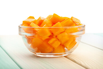 chopped persimmon on wood background on white