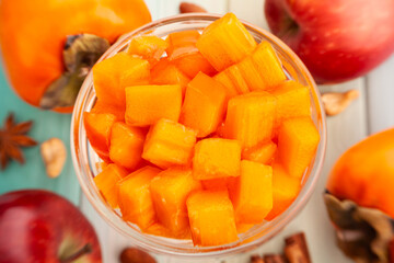 chopped persimmon on wood background