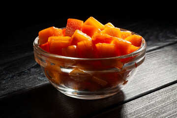 chopped persimmon on black wood background