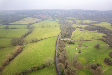 Obraz premium Aerial view of road and countryside of Fransham, Surrey, England. in a misty day