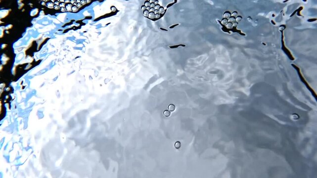 Bottom-up view, air bubbles in white foam on the surface of freshwater flowing from underground springs into the Black Sea
