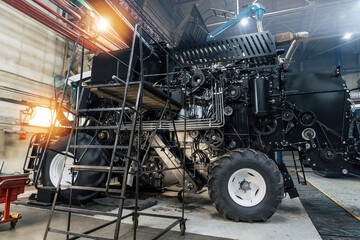 Combine harvester assembly in modern industrial workshop, detailed machinery, agricultural technology, production process, mechanical engineering, farming equipment manufacturing.