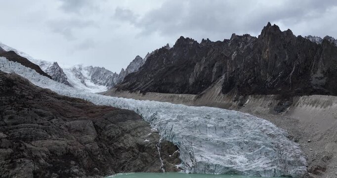 Beautiful high altitude hanging glacier and snow capped mountain with lake in Tibet, China