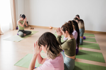 Diverse women practicing yoga meditation in studio