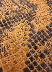 Abstract texture of a snake skin pattern in brown and black colors showing the scales and organic design for a luxury fashion or wildlife background with high resolution detail