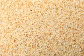 Granulated dried garlic as background, top view