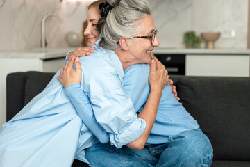 Elderly woman enjoys time with her adult daughter in a cozy living room