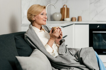 Woman holding coffee cup, enjoying drink at home