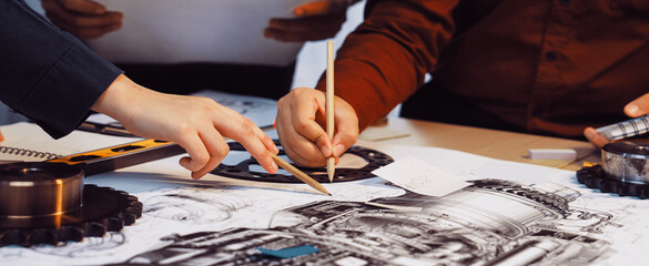 A group of engineers collaborates on intricate blueprints of mechanical components in a workshop, showcasing teamwork, creativity, and technical expertise through hands-on analysis. SACTR