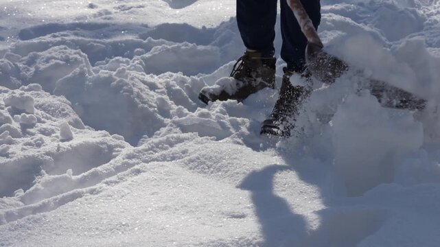 Man shoveling fresh snow on a sunny winter day close-up