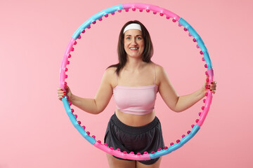 Happy woman with hula hoop on pink background