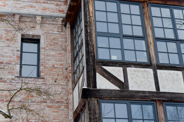 Traditional European building exterior with brick wall timber frame construction and large glass windows illustrating historic architecture detail