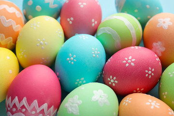 Naklejka premium Many painted Easter eggs on light blue background, closeup