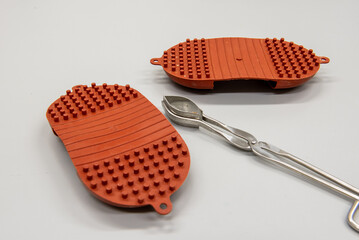 silicone hot pads and forceps on gray table in laboratory.