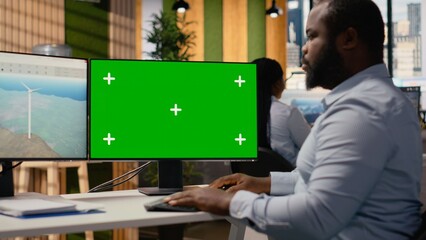 Technician works on wind turbine CAD design using green screen PC, doing renewable energy research. RD specialist does digital modeling of wind energy generator equipment on mockup computer, camera B