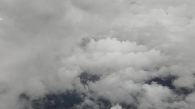 Aerial view from airplane of cumulus cloudscape seen from a window plane
