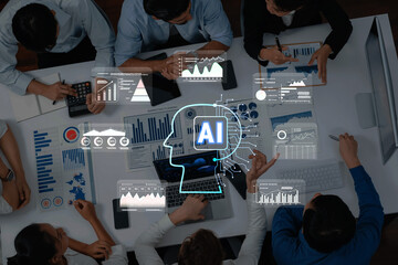 A group of professionals collaborates around a table, analyzing data visualizations with artificial intelligence concepts, highlighting teamwork and technology in a modern setting. Trope