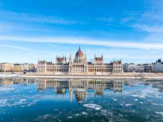 The Parliament of Hungary in Icy Winter time and it's mirrored picture on the freezing Danube,...