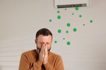 Man covering his nose because of bad smell from air conditioner indoors. Bacteria flying from...