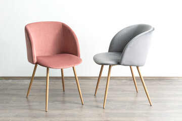 Obraz premium A modern interior decor featuring two stylish chairs placed against a white wall on a wooden floor
