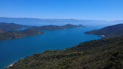Fototapeta premium Aerial view of tropical bay with blue ocean and green mountains