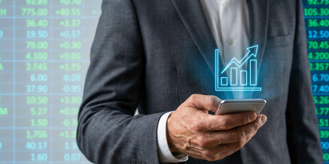 Business high level planning concept with investor hand holding smartphone and rising stock market chart overlay on digital screen background