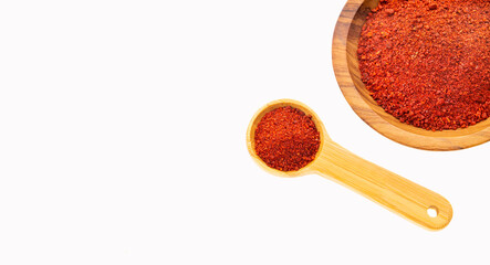 Ground or crushed organic annatto in the spoon and in the bowl - Bixa orellana