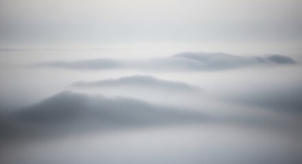 Fototapeta premium Serene Mountainscape - A Misty Mornings Gentle Embrace, Tranquil Peaks in the Distance.
