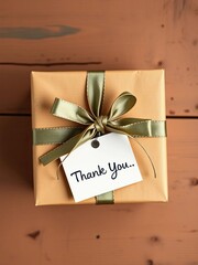 Overhead view of a gift box tied with a ribbon and a small card that says "Thank You", gift,  offering
