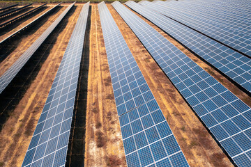 Solar power plant with multiple rows of photovoltaic panels installed on dry land generating clean renewable energy for sustainable development