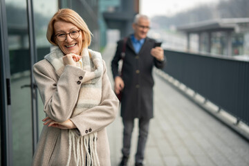 Obraz premium Happy mature woman smiling in urban setting