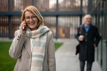 Mature woman smiling talking on mobile phone outdoors