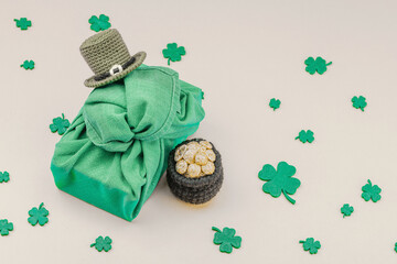 Handmade St. Patrick's Day gift concept. Furoshiki, decorative symbols, crocheted leprechaun hat