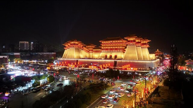 Hovering-level aerial video night view of Yingtian Gate in Luoyang, glowing with light show brilliance amid vibrant cityscape at the ancient capital, Henan Province, China