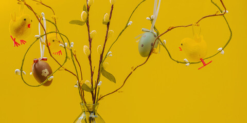 Traditional Easter tree composition with willow branches, handmade eggs and birds. Bright yellow