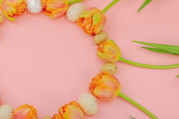 Blooming daffodils with Easter eggs and rabbits on light green background. Happy holiday concept