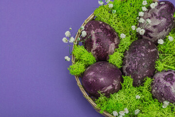 Marble Easter eggs, wooden basket, moss, gypsophila flowers. Festive concept, greeting card