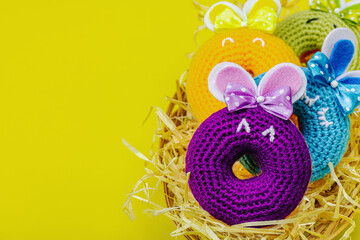 Handmade Easter concept. Crocheted donuts bunnies with traditional decoration. Festive symbols