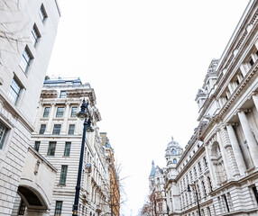 London street architecture with ornate classical buildings and a lamppost under a high bright sky, city urban scene