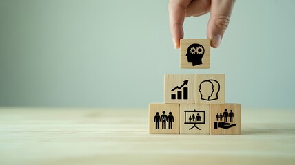 A hand arranging wooden blocks with business icons on a minimalist table