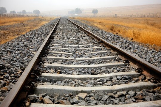 Railway tracks disappear into the hazy horizon