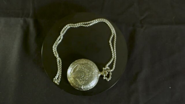 Static shot of an open vintage watch on a table.