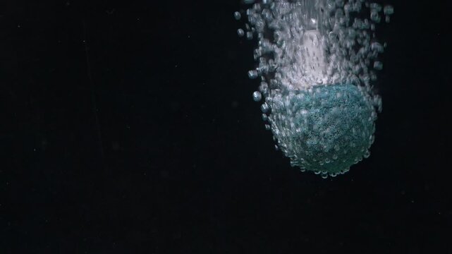 Aquarium air stone releasing bubbles in dark background with copy space