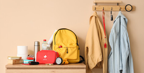 Emergency backpack with necessities on chest of drawers in hallway