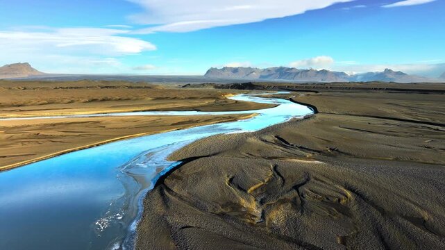 Glacial river in Iceland, Fast river flows between dunes of black volcanic sand, Nature water pattern