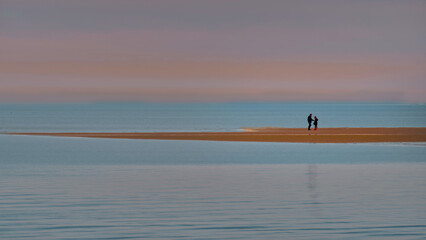 A lovely couple  standing together on the sand bar of the beach during low tide